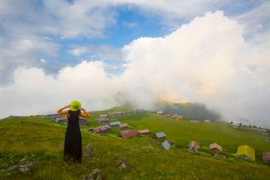 Türkiye'nin kuzeydoğusundaki Karadeniz bölgesinin yeşil doğası, karlı dağları ve geleneksel ahşap yayla evleri (yayla evi). Haziran 2019'da Rize'nin Pokut Yaylası'nda manzara çekimi yapıldı.