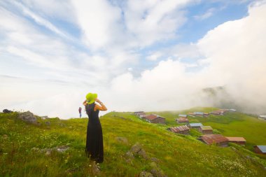 Türkiye'nin kuzeydoğusundaki Karadeniz bölgesinin yeşil doğası, karlı dağları ve geleneksel ahşap yayla evleri (yayla evi). Haziran 2019'da Rize'nin Pokut Yaylası'nda manzara çekimi yapıldı.