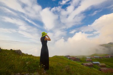 Türkiye'nin kuzeydoğusundaki Karadeniz bölgesinin yeşil doğası, karlı dağları ve geleneksel ahşap yayla evleri (yayla evi). Haziran 2019'da Rize'nin Pokut Yaylası'nda manzara çekimi yapıldı.