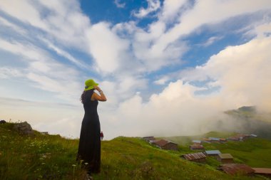 Türkiye'nin kuzeydoğusundaki Karadeniz bölgesinin yeşil doğası, karlı dağları ve geleneksel ahşap yayla evleri (yayla evi). Haziran 2019'da Rize'nin Pokut Yaylası'nda manzara çekimi yapıldı.