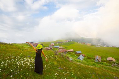 Türkiye'nin kuzeydoğusundaki Karadeniz bölgesinin yeşil doğası, karlı dağları ve geleneksel ahşap yayla evleri (yayla evi). Haziran 2019'da Rize'nin Pokut Yaylası'nda manzara çekimi yapıldı.