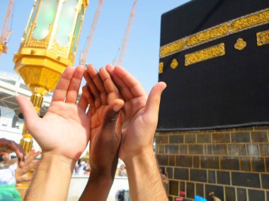 Mecca, Saudi Arabia (08/30/2018) : praying hands of a hajj pilgrim in front of the Kaaba in Masjidil Haram during hajj session. clipart