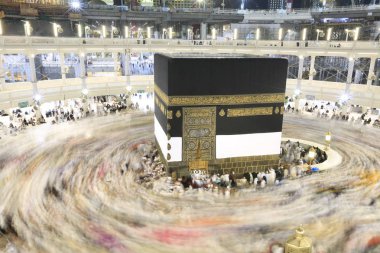 Dünyanın dört bir yanından gelen Müslüman hacılar, Suudi Arabistan'da Hac sırasında geceleri Kabe'yi geziyor. Hareket bulanıklığı yakalamak için uzun süre maruz kaldı.