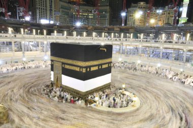 Dünyanın dört bir yanından gelen Müslüman hacılar, Suudi Arabistan'da Hac sırasında geceleri Kabe'yi geziyor. Hareket bulanıklığı yakalamak için uzun süre maruz kaldı.