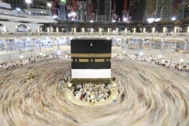 Dünyanın dört bir yanından gelen Müslüman hacılar, Suudi Arabistan'da Hac sırasında geceleri Kabe'yi geziyor. Hareket bulanıklığı yakalamak için uzun süre maruz kaldı.