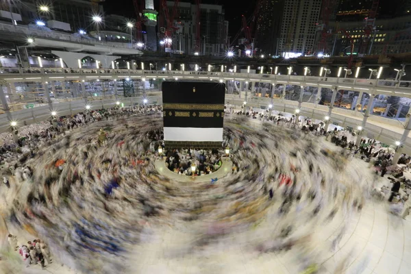 Dünyanın dört bir yanından gelen Müslüman hacılar, Suudi Arabistan'da Hac sırasında geceleri Kabe'yi geziyor. Hareket bulanıklığı yakalamak için uzun süre maruz kaldı.