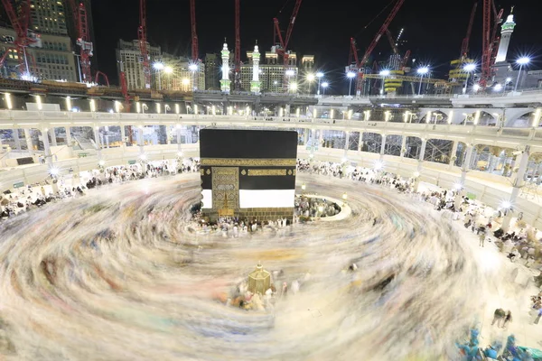 Dünyanın dört bir yanından gelen Müslüman hacılar, Suudi Arabistan'da Hac sırasında geceleri Kabe'yi geziyor. Hareket bulanıklığı yakalamak için uzun süre maruz kaldı.