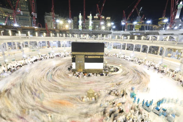 Dünyanın dört bir yanından gelen Müslüman hacılar, Suudi Arabistan'da Hac sırasında geceleri Kabe'yi geziyor. Hareket bulanıklığı yakalamak için uzun süre maruz kaldı.