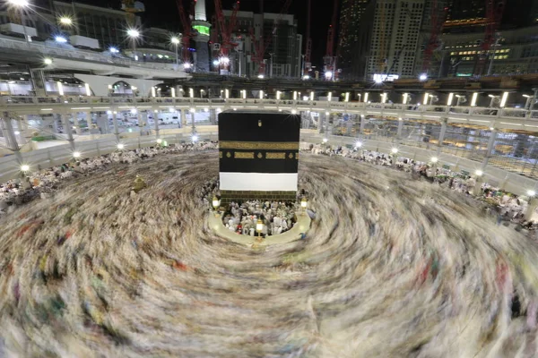 Dünyanın dört bir yanından gelen Müslüman hacılar, Suudi Arabistan'da Hac sırasında geceleri Kabe'yi geziyor. Hareket bulanıklığı yakalamak için uzun süre maruz kaldı.
