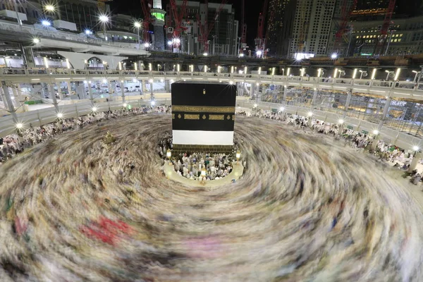 Dünyanın dört bir yanından gelen Müslüman hacılar, Suudi Arabistan'da Hac sırasında geceleri Kabe'yi geziyor. Hareket bulanıklığı yakalamak için uzun süre maruz kaldı.