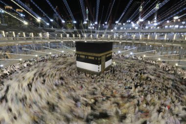 Dünyanın dört bir yanından gelen Müslüman hacılar, Suudi Arabistan'da Hac sırasında geceleri Kabe'yi geziyor. Hareket bulanıklığı yakalamak için uzun süre maruz kaldı.