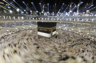 Dünyanın dört bir yanından gelen Müslüman hacılar, Suudi Arabistan'da Hac sırasında geceleri Kabe'yi geziyor. Hareket bulanıklığı yakalamak için uzun süre maruz kaldı.