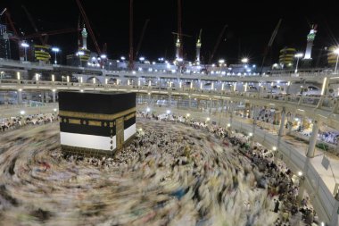 Dünyanın dört bir yanından gelen Müslüman hacılar, Suudi Arabistan'da Hac sırasında geceleri Kabe'yi geziyor. Hareket bulanıklığı yakalamak için uzun süre maruz kaldı.