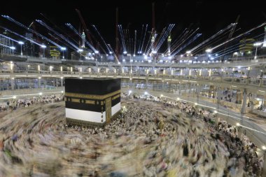 Dünyanın dört bir yanından gelen Müslüman hacılar, Suudi Arabistan'da Hac sırasında geceleri Kabe'yi geziyor. Hareket bulanıklığı yakalamak için uzun süre maruz kaldı.