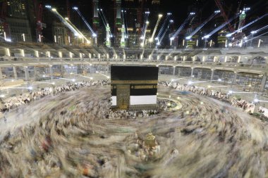 Dünyanın dört bir yanından gelen Müslüman hacılar, Suudi Arabistan'da Hac sırasında geceleri Kabe'yi geziyor. Hareket bulanıklığı yakalamak için uzun süre maruz kaldı.