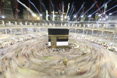 Dünyanın dört bir yanından gelen Müslüman hacılar, Suudi Arabistan'da Hac sırasında geceleri Kabe'yi geziyor. Hareket bulanıklığı yakalamak için uzun süre maruz kaldı.