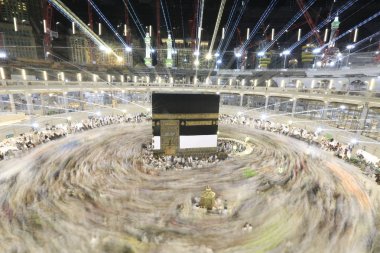 Dünyanın dört bir yanından gelen Müslüman hacılar, Suudi Arabistan'da Hac sırasında geceleri Kabe'yi geziyor. Hareket bulanıklığı yakalamak için uzun süre maruz kaldı.