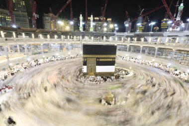 Dünyanın dört bir yanından gelen Müslüman hacılar, Suudi Arabistan'da Hac sırasında geceleri Kabe'yi geziyor. Hareket bulanıklığı yakalamak için uzun süre maruz kaldı.