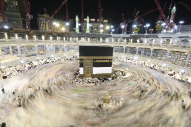 Dünyanın dört bir yanından gelen Müslüman hacılar, Suudi Arabistan'da Hac sırasında geceleri Kabe'yi geziyor. Hareket bulanıklığı yakalamak için uzun süre maruz kaldı.