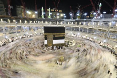 Dünyanın dört bir yanından gelen Müslüman hacılar, Suudi Arabistan'da Hac sırasında geceleri Kabe'yi geziyor. Hareket bulanıklığı yakalamak için uzun süre maruz kaldı.