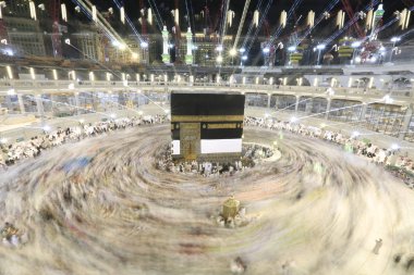 Dünyanın dört bir yanından gelen Müslüman hacılar, Suudi Arabistan'da Hac sırasında geceleri Kabe'yi geziyor. Hareket bulanıklığı yakalamak için uzun süre maruz kaldı.