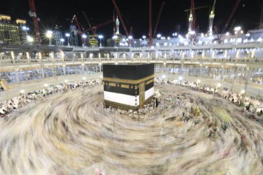 Dünyanın dört bir yanından gelen Müslüman hacılar, Suudi Arabistan'da Hac sırasında geceleri Kabe'yi geziyor. Hareket bulanıklığı yakalamak için uzun süre maruz kaldı.