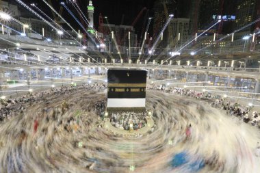 Dünyanın dört bir yanından gelen Müslüman hacılar, Suudi Arabistan'da Hac sırasında geceleri Kabe'yi geziyor. Hareket bulanıklığı yakalamak için uzun süre maruz kaldı.