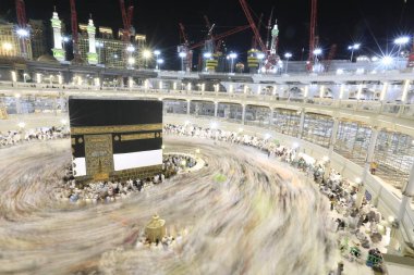 Dünyanın dört bir yanından gelen Müslüman hacılar, Suudi Arabistan'da Hac sırasında geceleri Kabe'yi geziyor. Hareket bulanıklığı yakalamak için uzun süre maruz kaldı.