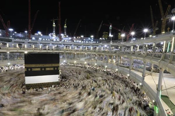 Dünyanın dört bir yanından gelen Müslüman hacılar, Suudi Arabistan'da Hac sırasında geceleri Kabe'yi geziyor. Hareket bulanıklığı yakalamak için uzun süre maruz kaldı.