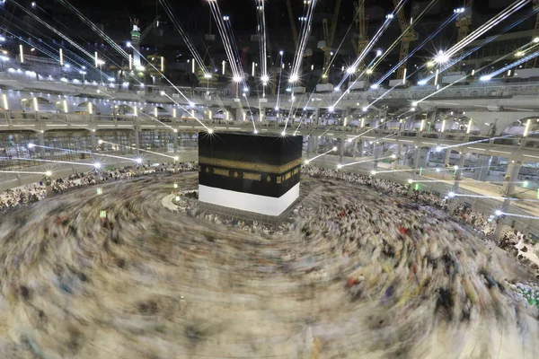 Dünyanın dört bir yanından gelen Müslüman hacılar, Suudi Arabistan'da Hac sırasında geceleri Kabe'yi geziyor. Hareket bulanıklığı yakalamak için uzun süre maruz kaldı.