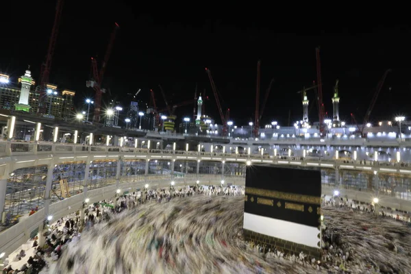 Dünyanın dört bir yanından gelen Müslüman hacılar, Suudi Arabistan'da Hac sırasında geceleri Kabe'yi geziyor. Hareket bulanıklığı yakalamak için uzun süre maruz kaldı.