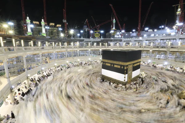 Dünyanın dört bir yanından gelen Müslüman hacılar, Suudi Arabistan'da Hac sırasında geceleri Kabe'yi geziyor. Hareket bulanıklığı yakalamak için uzun süre maruz kaldı.