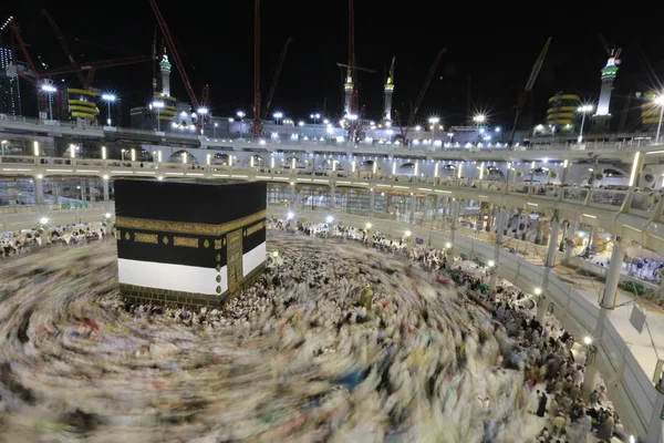 Dünyanın dört bir yanından gelen Müslüman hacılar, Suudi Arabistan'da Hac sırasında geceleri Kabe'yi geziyor. Hareket bulanıklığı yakalamak için uzun süre maruz kaldı.