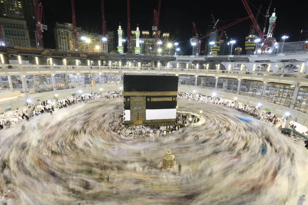 Dünyanın dört bir yanından gelen Müslüman hacılar, Suudi Arabistan'da Hac sırasında geceleri Kabe'yi geziyor. Hareket bulanıklığı yakalamak için uzun süre maruz kaldı.