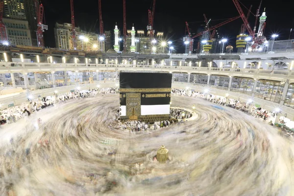 Dünyanın dört bir yanından gelen Müslüman hacılar, Suudi Arabistan'da Hac sırasında geceleri Kabe'yi geziyor. Hareket bulanıklığı yakalamak için uzun süre maruz kaldı.