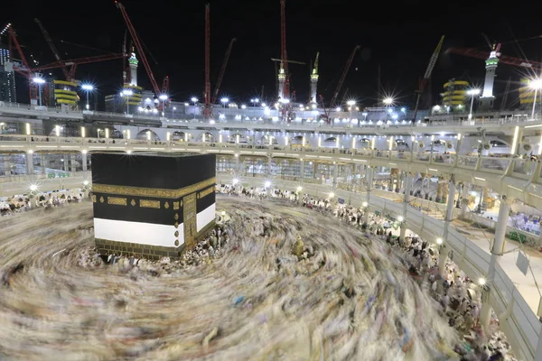 Dünyanın dört bir yanından gelen Müslüman hacılar, Suudi Arabistan'da Hac sırasında geceleri Kabe'yi geziyor. Hareket bulanıklığı yakalamak için uzun süre maruz kaldı.