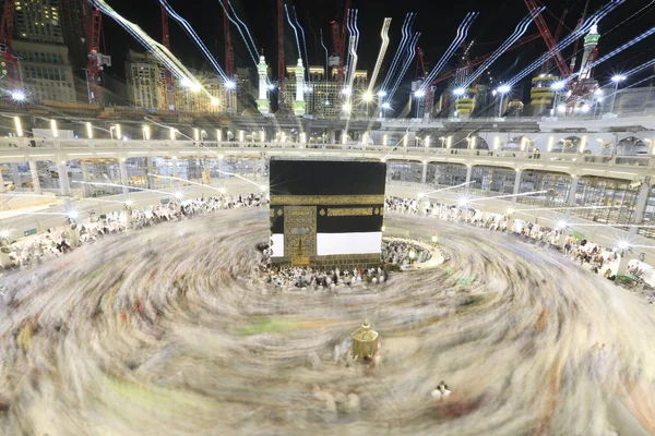 Dünyanın dört bir yanından gelen Müslüman hacılar, Suudi Arabistan'da Hac sırasında geceleri Kabe'yi geziyor. Hareket bulanıklığı yakalamak için uzun süre maruz kaldı.