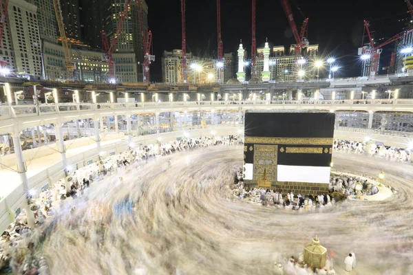 Dünyanın dört bir yanından gelen Müslüman hacılar, Suudi Arabistan'da Hac sırasında geceleri Kabe'yi geziyor. Hareket bulanıklığı yakalamak için uzun süre maruz kaldı.