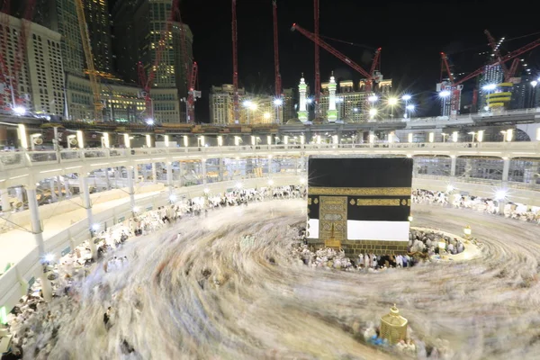Dünyanın dört bir yanından gelen Müslüman hacılar, Suudi Arabistan'da Hac sırasında geceleri Kabe'yi geziyor. Hareket bulanıklığı yakalamak için uzun süre maruz kaldı.