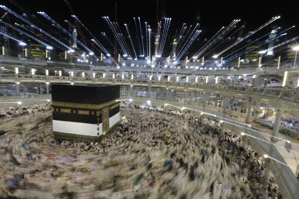 Dünyanın dört bir yanından gelen Müslüman hacılar, Suudi Arabistan'da Hac sırasında geceleri Kabe'yi geziyor. Hareket bulanıklığı yakalamak için uzun süre maruz kaldı.