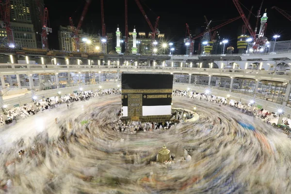 Dünyanın dört bir yanından gelen Müslüman hacılar, Suudi Arabistan'da Hac sırasında geceleri Kabe'yi geziyor. Hareket bulanıklığı yakalamak için uzun süre maruz kaldı.