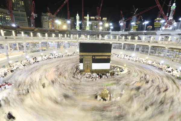 Dünyanın dört bir yanından gelen Müslüman hacılar, Suudi Arabistan'da Hac sırasında geceleri Kabe'yi geziyor. Hareket bulanıklığı yakalamak için uzun süre maruz kaldı.