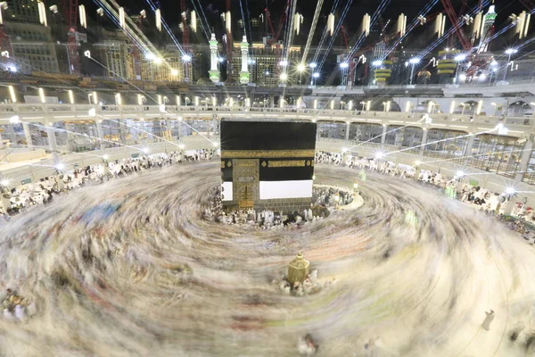 Dünyanın dört bir yanından gelen Müslüman hacılar, Suudi Arabistan'da Hac sırasında geceleri Kabe'yi geziyor. Hareket bulanıklığı yakalamak için uzun süre maruz kaldı.