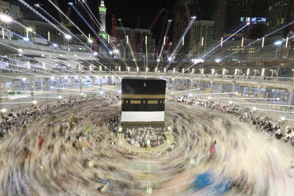 Dünyanın dört bir yanından gelen Müslüman hacılar, Suudi Arabistan'da Hac sırasında geceleri Kabe'yi geziyor. Hareket bulanıklığı yakalamak için uzun süre maruz kaldı.