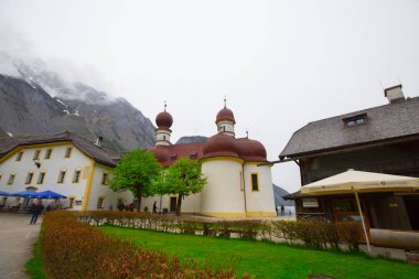 Yazın güneşli bir günde dünyaca ünlü Sankt Bartholomae hac kilisesi ve Watzmann Dağı ile Konigssee Gölü 'nün klasik panoramik manzarası, Berchtesgadener Toprakları, Bavyera, Almanya