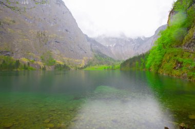 Yaz aylarında mavi gökyüzü ve bulutlar ile güzel bir güneşli bir günde doğal Obersee Gölü'nde geleneksel eski ahşap tekne evi Pastoral görünümü, Millipark Berchtesgadener Land, Bavyera, Almanya