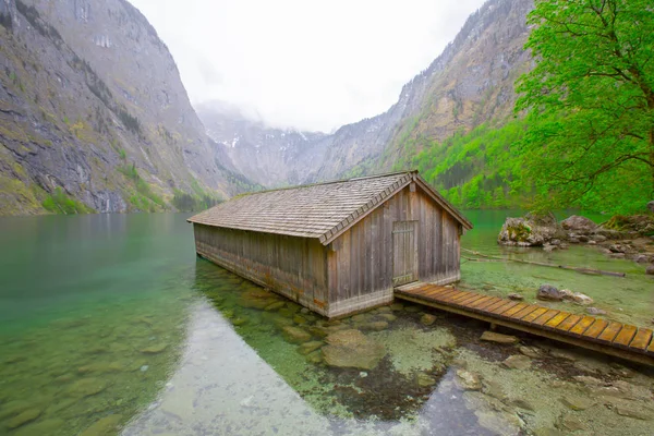 Yaz aylarında mavi gökyüzü ve bulutlar ile güzel bir güneşli bir günde doğal Obersee Gölü'nde geleneksel eski ahşap tekne evi Pastoral görünümü, Millipark Berchtesgadener Land, Bavyera, Almanya
