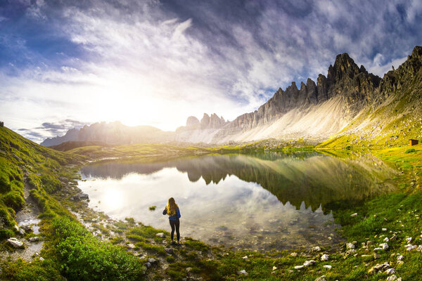 Beautiful view of famous Tre Cime di Lavaredo mountains in the Dolomites mountain range with famous Rifugio Antonio Locatelli alpine hut on a clear starry night in summer, South Tyrol, Italy