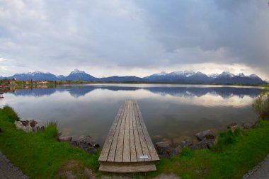 Bavyera Alpleri'ndeki Hopfensee Gölü'ne giden uzun ahşap iskele