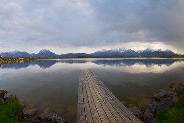 Bavyera Alpleri'ndeki Hopfensee Gölü'ne giden uzun ahşap iskele